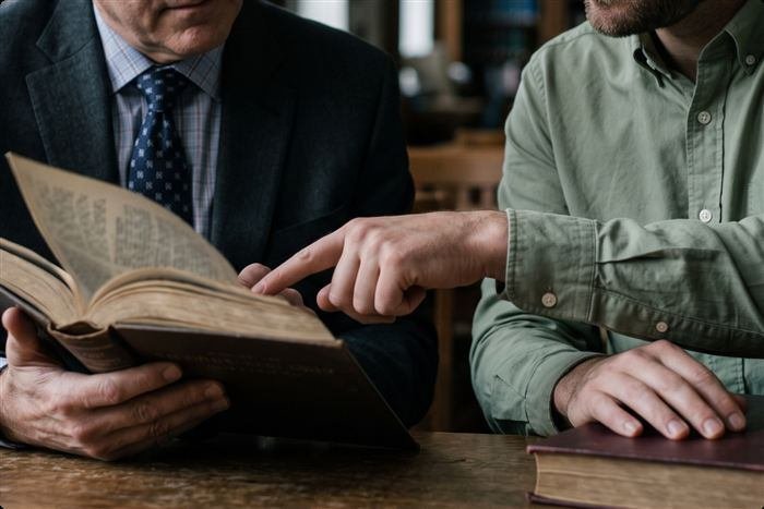 Pastor discipulando a un joven con la Biblia abierta